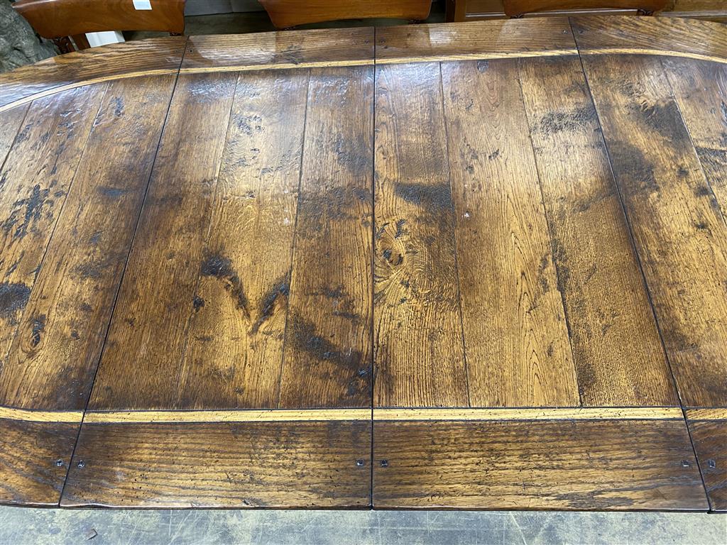 An 18th century style cross banded oak D end twin pillar extending dining table, 284cm extended, two spare leaves, width 130cm, height